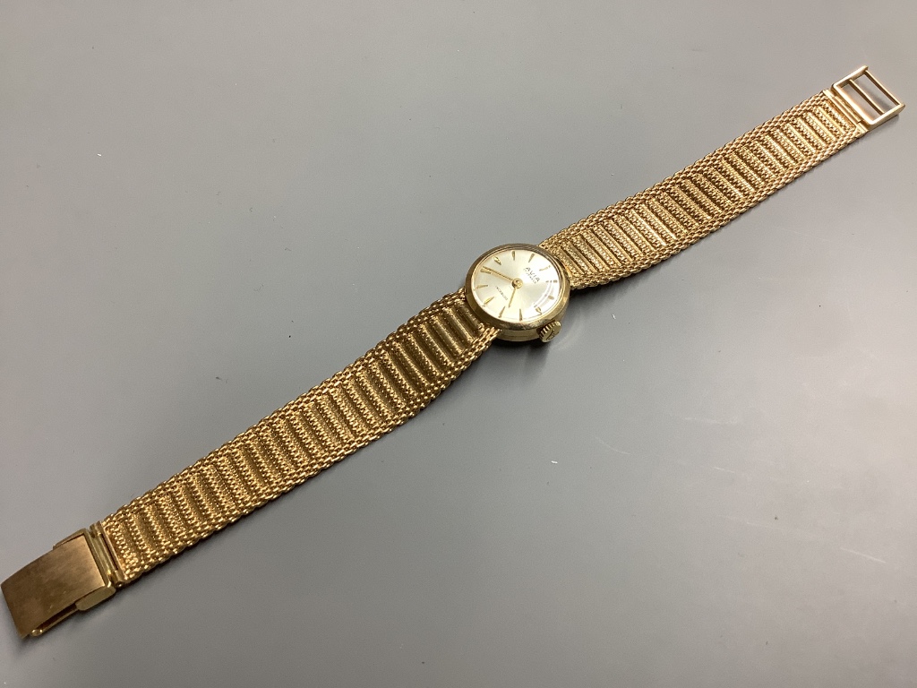 A lady's modern 9ct gold Avia manual wind wrist watch, on integral 9ct gold bracelet, overall 17.5cm